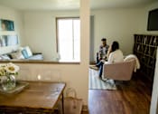 Thumbnail 5 of 26 - Two people sitting on a couch in a living room at Sutton Hill Apartments, Des Moines, 50320