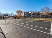Thumbnail 14 of 26 - an empty parking lot with an apartment building in the background at Sutton Hill Apartments, IOWA