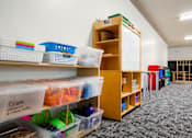 Thumbnail 26 of 26 - a classroom with shelves and bins and a whiteboard at Sutton Hill Apartments, IOWA, 50320