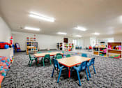 Thumbnail 24 of 26 - a preschool classroom with tables and chairs and toys at Sutton Hill Apartments, Des Moines, IA