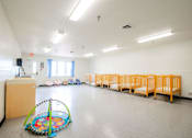 Thumbnail 19 of 26 - a multipurpose room with children cribs and a baby play area at Sutton Hill Apartments, IOWA