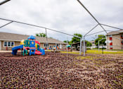 Thumbnail 22 of 26 - a playground with a play set in front of a building at Sutton Hill Apartments, Des Moines, IOWA