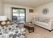 Thumbnail 1 of 26 - a living room with a couch and a chair and a sliding glass door at Sutton Hill Apartments, IOWA