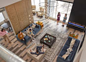Thumbnail 18 of 40 - people in a living room with couches and a tv at Velocity Apartments, Iowa
