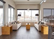 Thumbnail 16 of 40 - a living room with white couches and a view of the city at Velocity Apartments, Des Moines