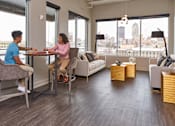 Thumbnail 17 of 40 - Two people sitting at a table in a room with a view of the city at Velocity Apartments, Iowa, 50309