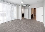 Thumbnail 13 of 40 - A room with a grey carpet and white walls at Velocity Apartments, Des Moines, IA