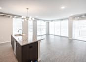 Thumbnail 6 of 40 - A kitchen with a granite countertop and a sink at Velocity Apartments, IA, 50309