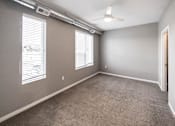 Thumbnail 10 of 40 - A room with a carpeted floor and a ceiling fan at Velocity Apartments, Des Moines, Iowa