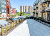 Thumbnail 26 of 40 - A gravel pathway leads through a residential area with apartment buildings on either side at Velocity Apartments, Des Moines, Iowa
