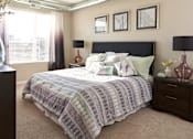 Thumbnail 9 of 40 - a bedroom with a bed and a dresser and a window at Velocity Apartments, Iowa