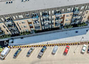 Thumbnail 36 of 40 - an aerial view of a parking lot with cars in front of an apartment building at Velocity Apartments, Iowa