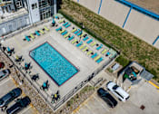 Thumbnail 21 of 40 - an aerial view of a swimming pool with lounge chairs around it at Velocity Apartments, IA, 50309