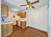 Thumbnail 4 of 20 - a kitchen with wood floors and a ceiling fan at Foxwood Apartments, Iowa  