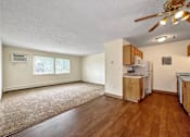 Thumbnail 1 of 20 - an empty living room with a kitchen and a ceiling fan at Foxwood Apartments, Indianola, 50125  