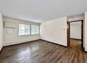 Thumbnail 13 of 20 - an empty living room with white walls and wood floors at Foxwood Apartments, Iowa  