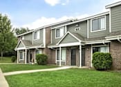 Thumbnail 21 of 24 - A row of houses with green lawns in front at Hunters Run Apartments, IA, 50208
