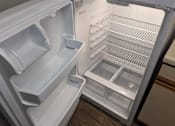 Thumbnail 4 of 24 - A white refrigerator with the door open showing the shelves and drawers at Hunters Run Apartments, Newton