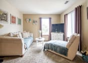 Thumbnail 1 of 24 - A living room with a couch, chair, and a small table at Hunters Run Apartments, Iowa, 50208