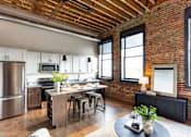Thumbnail 36 of 99 - A kitchen with a brick wall and wooden ceiling.at Plant 1 Lofts, Iowa, 50208