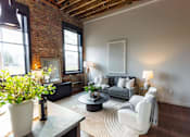 Thumbnail 37 of 99 - A living room with a grey couch and a white chair.at Plant 1 Lofts, N. Newton, 50208  