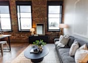 Thumbnail 39 of 99 - A living room with a grey couch and a black coffee table.at Plant 1 Lofts, Iowa   