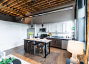 Thumbnail 24 of 99 - A kitchen with a wooden ceiling and a table with chairs.at Plant 1 Lofts, N. Newton, IA  