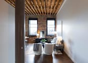 Thumbnail 44 of 99 - A living room with a white couch and a wooden floor.at Plant 1 Lofts, N. Newton, 50208  