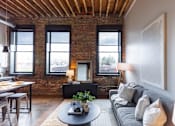 Thumbnail 46 of 99 - A living room with a grey couch and a round coffee table.at Plant 1 Lofts, N. Newton, IA 50208  