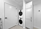 Thumbnail 66 of 99 - A laundry room with a washer and dryer stacked on top of each other.at Plant 1 Lofts, N. Newton  