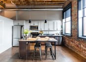 Thumbnail 25 of 99 - A kitchen with a table and chairs in the middle of it.at Plant 1 Lofts, N. Newton, IA  