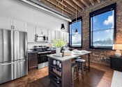 Thumbnail 53 of 99 - A kitchen with a stainless steel refrigerator and a brick wall.at Plant 1 Lofts, Iowa, 50208