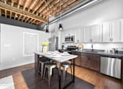 Thumbnail 54 of 99 - A kitchen with a table and chairs in front of a dishwasher and a microwave.at Plant 1 Lofts, N. Newton  