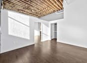 Thumbnail 73 of 99 - A room with wooden floors and a white wall with a doorway leading to another room.at Plant 1 Lofts, Iowa, 50208