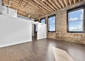 Thumbnail 62 of 99 - A room with wooden floors and a brick wall.at Plant 1 Lofts, N. Newton, IA  