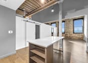 Thumbnail 77 of 99 - A kitchen with a white countertop and wooden floors.at Plant 1 Lofts, Iowa, 50208
