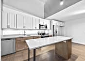 Thumbnail 78 of 99 - A modern kitchen with a large island in the center.at Plant 1 Lofts, N. Newton Iowa   