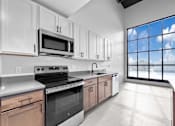 Thumbnail 80 of 99 - A kitchen with white cabinets and a large window.at Plant 1 Lofts, N. Newton, 50208  