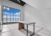 Thumbnail 83 of 99 - A white room with a table and a window showing a blue sky.at Plant 1 Lofts, N. Newton, 50208  