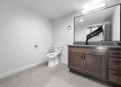 Thumbnail 88 of 99 - A bathroom with a toilet, vanity, and mirror.at Plant 1 Lofts, Iowa   