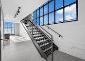 Thumbnail 89 of 99 - A staircase with a metal railing leads up to a window with a view of the sky.at Plant 1 Lofts, N. Newton, IA 50208  