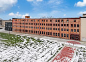Thumbnail 98 of 99 - A large red brick building with a green lawn in front.at Plant 1 Lofts, N. Newton, IA 50208  
