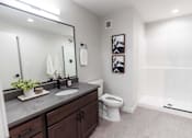 Thumbnail 34 of 99 - A bathroom with a toilet, sink, and mirror.at Plant 1 Lofts, N. Newton  