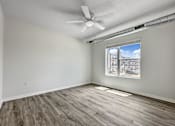 Thumbnail 29 of 42 - an empty living room with a ceiling fan and a window at Forge65, Iowa, 50327