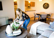 Thumbnail 4 of 57 - a woman arranging flowers on a coffee table in a living room at Bristol Ridge, Urbandale, IA, 50322