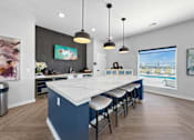 Thumbnail 41 of 57 - a kitchen with a large marble counter top and bar stools at Rialto Townhomes Apartments, Waukee, 50263