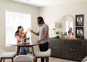 Thumbnail 38 of 57 - a man serves a woman a drink at a dining room table at Rialto Townhomes Apartments, Waukee, Iowa
