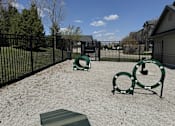 Thumbnail 34 of 50 - A playground with a green slide and a black fence.