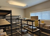 Thumbnail 36 of 50 - A storage room with shelves filled with boxes and a sign that reads "20-212".