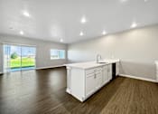 Thumbnail 23 of 51 - A kitchen with white cabinets and a wooden floor.